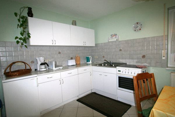 White fitted kitchen with stove, oven and sink